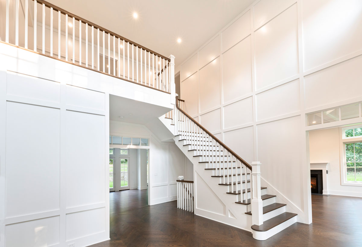 Long Island Architect Design Custom Entry and Stairwell with White Paneled Walls